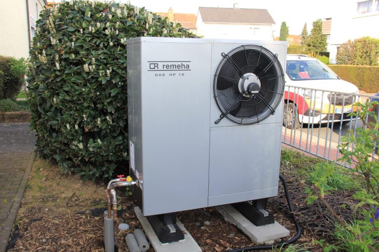 Mitarbeiter von Heizungsbau Oberhessen präsentieren die fertig montierte Wärmepumpe